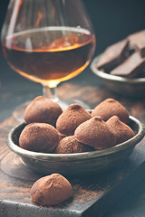 Sweet chocolate truffles sprinkled with cocoa powder close-up on the table