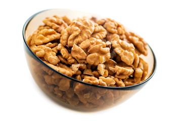Studio photo of bowl with heap of peeled walnuts isolated on white