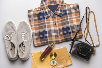 Male clothes with travel objects on light background