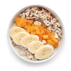 Bowl with tasty sweet oatmeal on white background