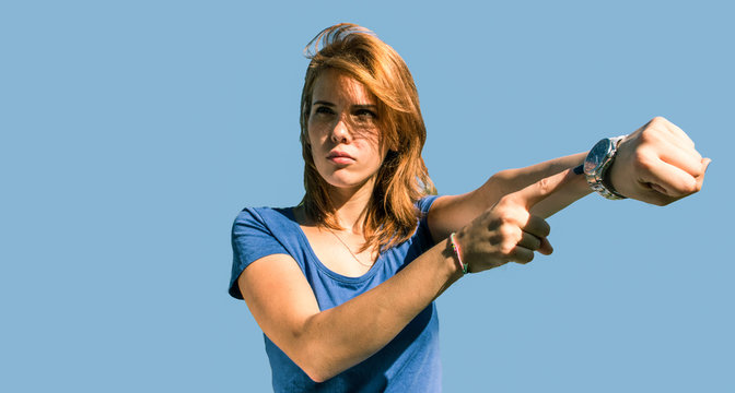 angry woman unhappy for being too late, showing wrist watch, very disappointed facial expression isolated on blue.  concept of too late and stress.