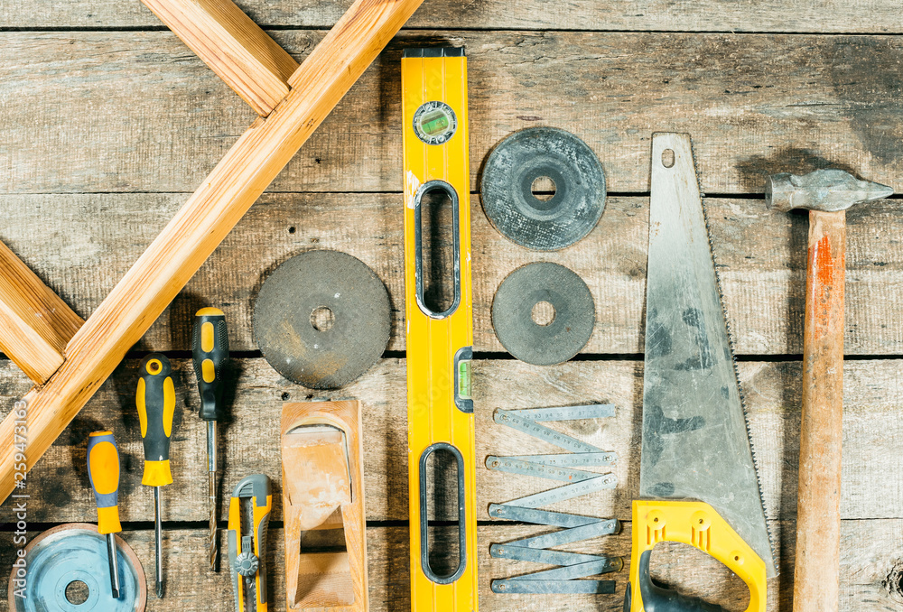 Wall mural Working tools on wooden rustic background.