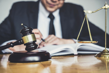 Male lawyer or judge working with contract papers, Law books and wooden gavel on table in courtroom, Justice lawyers at law firm, Law and Legal services concept