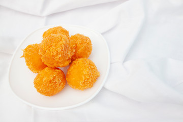 Fried Cheese balls covered bread crumb in white plate.