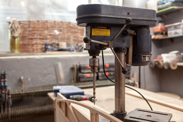 Industrial Iron drill ready for work in workshop interior. Close up on the drilling machine