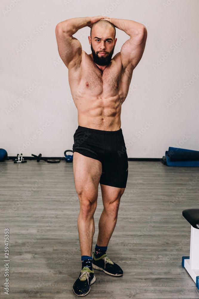 Wall mural muscular guy in the gym