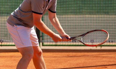 Fototapeta na wymiar A man plays tennis on the court in the park