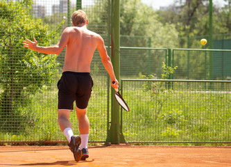 Obraz premium A man plays tennis on the court in the park