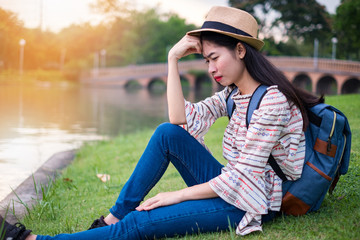 asian woman tourists backpacker. he was crying sad and disappointed with life. she has a unhappy. during travel. at the waterfront public park. in the holiday and relax.