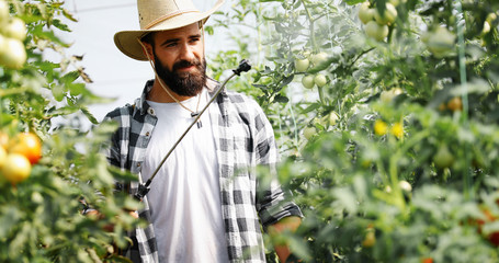 Young farmer protecting his plants with chemicals