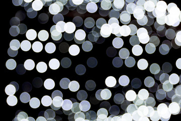 Abstract bokeh of white city lights on black background. defocused and blurred many round light