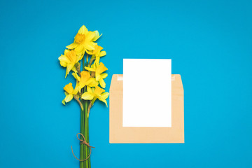 Fresh bouquet of flowers of narcissus on a bright blue background. Greeting card layout for positive ideas. Empty place for inspirational, emotional, sentimental text or quotation.