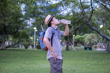 asian young man age 25-30 year tourists backpacker. he was thirsty and was drinking water from a plastic bottle. during travel the holidays and relax.