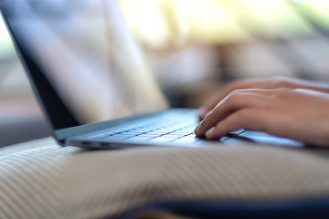 Fototapeta premium Closeup image of woman's hands using and typing on laptop keyboard