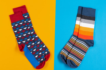 two pairs of colored unisex socks lie on a blue and yellow background, concept