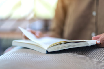 Closeup image of a woman opening and reading a book