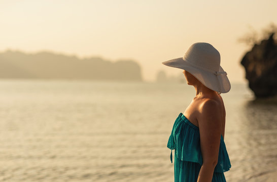 Holidays in tropics, woman at susnet on coast
