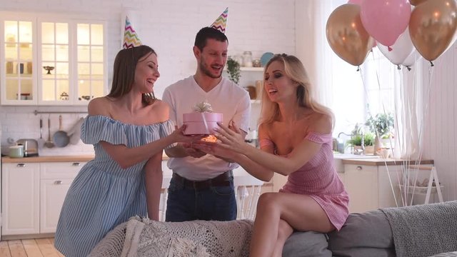 Birthday party of young pretty woman blowing out candles on birthday cake
