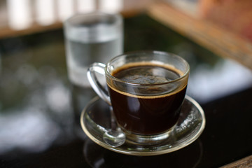 Cup of black coffee on the table at the cafe.