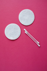 Cotton swabs and disks isolated on a pink background. Hygiene products.