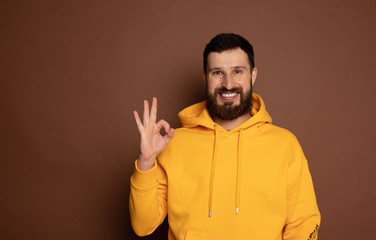 Image of positive bearded man laughing and showing ok sign