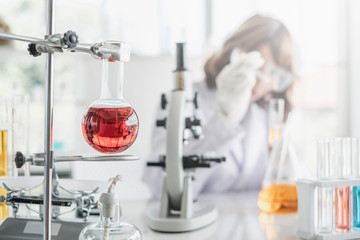 Fototapeta premium A young Asian woman scientist working in laboratory with test tube microscope and solutions.