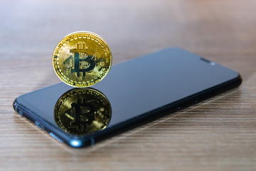 Bitcoin coin with a smartphone screen.