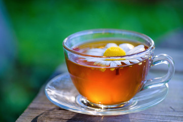 A cup of fragrant, fragrant tea, in the rays of the evening warm sunset.