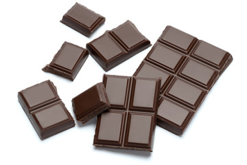 Dark organic chocolate pieces isolated on white background