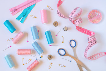 Fototapeta premium Sewing accessories for needlework in pink and purple and blue tones on white background