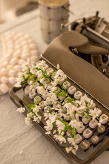 Spring or summer writing concept. Vintage typerwriter with flowers between keys