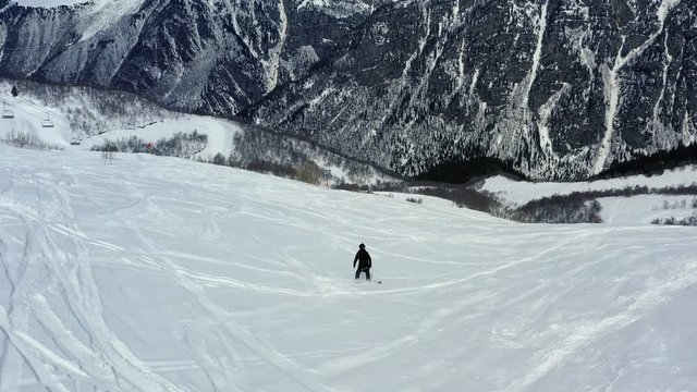 A guy falls while freeriding on the snowboard, gorgeous mountain on the background, 4k