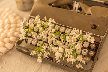 Spring or summer writing concept. Vintage typerwriter with flowers between keys
