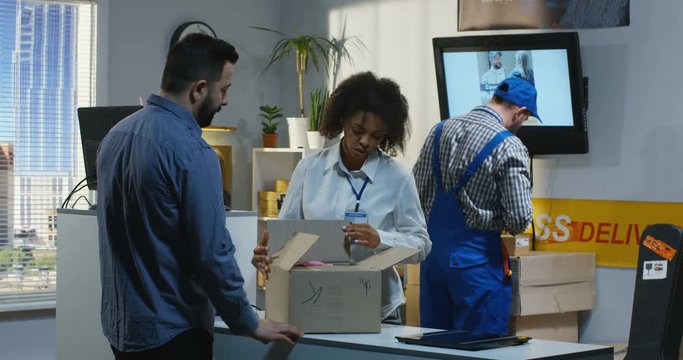 Man sending a package in a delivery center