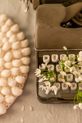 Spring or summer writing concept. Vintage typerwriter with flowers between keys