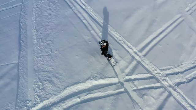 Top view of a man freeriding in the mountains on fresh powder snow, 4k