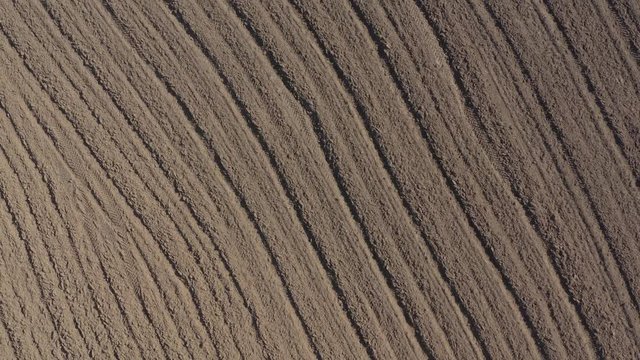 Above the furrows made in fertile soil 4K aerial video