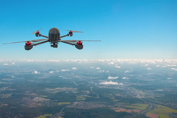 Drone with four screws high in the sky over the city.