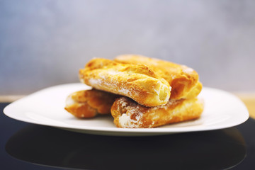 eclairs cakes lie on a white plate.  sweet cakes eclairs