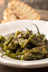 Green Padron Peppers with Crisp Bread in Rustic White Plate. Pimientos de Padrón. - 259492116