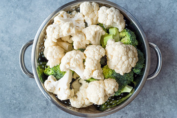 Organic Raw Cauliflower and Broccoli in Metal Colander.