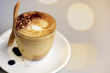 Hot latte coffee on the table with blurred bokeh background.