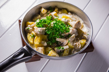 Fried potatoes with chicken, mushroom sauce and onion