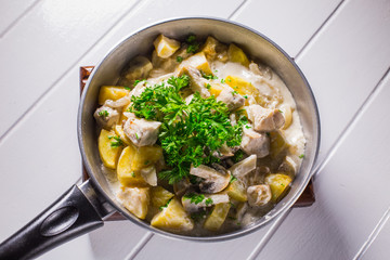 Fried potatoes with chicken, mushroom sauce and onion