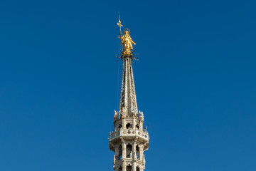 Fototapeta na wymiar Golden statue of Virgin Mary, placed at the rooftop of Duomo cathedral in Milan, Italy