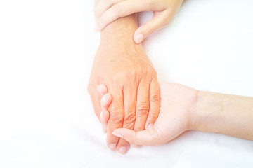 Asian senior and asian young holding hands.