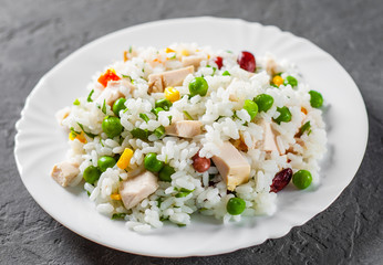 Chicken Breast with Rice and vegetables in white plate on Dark grey black slate background