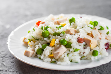 Chicken Breast with Rice and vegetables in white plate on Dark grey black slate background