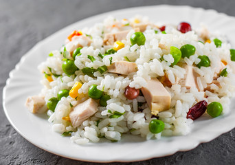 Chicken Breast with Rice and vegetables in white plate on Dark grey black slate background