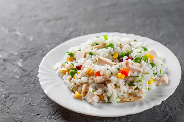 Chicken Breast with Rice and vegetables in white plate on Dark grey black slate background